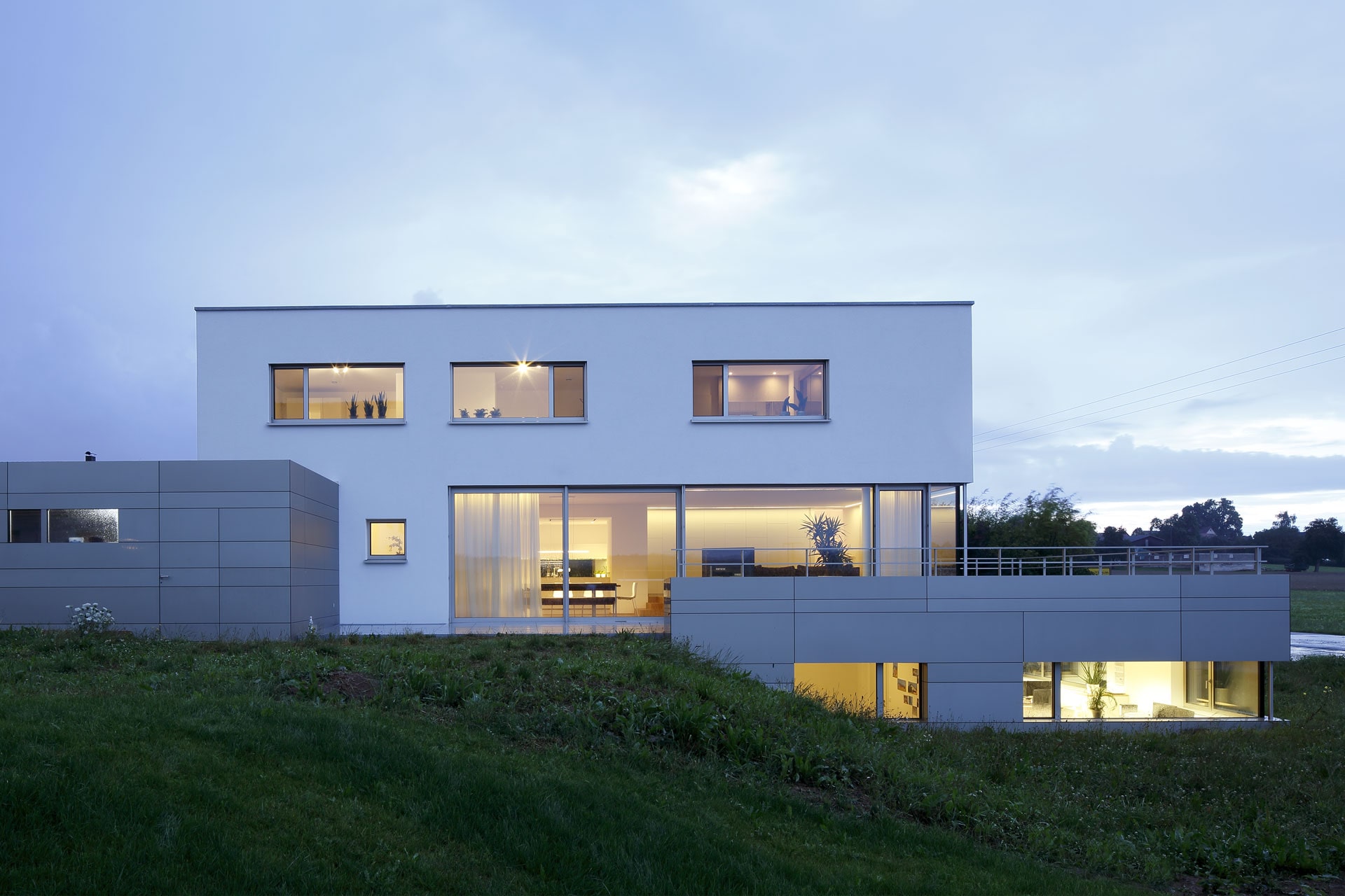 Modernes Wohnhaus am Hang mit großen Fensterflächen