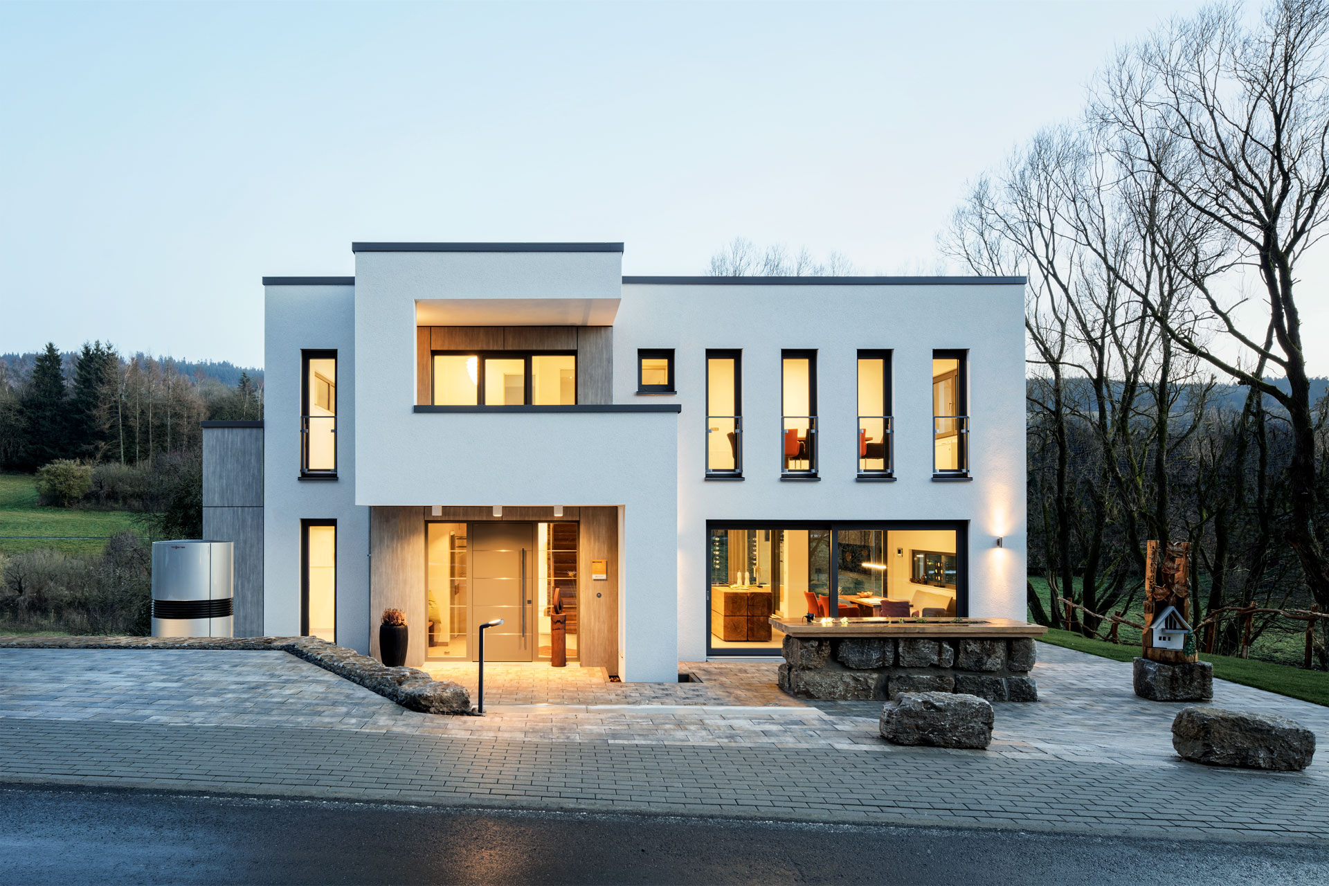 Musterhaus mit großen Fenstern am Abend